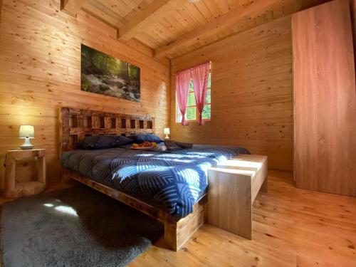a bedroom with a bed in a wooden cabin at Wooden house with a waterfall "Stipanov mlin" in Plitvička Jezera