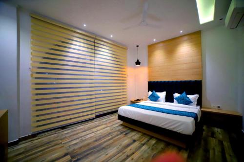 a bedroom with a bed and a large window at Hotel Diamond View in Amritsar