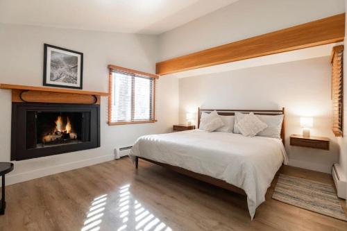 a bedroom with a bed and a fireplace at Spacious 3 bedroom townhouse with tennis courts in Vail