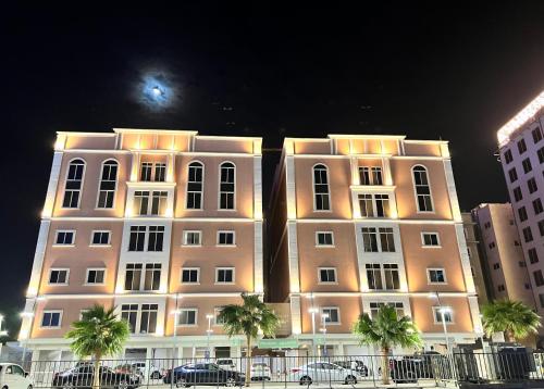 a large white building with cars parked in front of it at Mandarin residneces Alkhobar , شقق ماندارين الخبر in Al Khobar