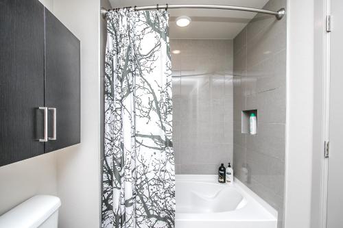 a bathroom with a shower with a black and white patterned shower curtain at Rooftop Pool - Golf, Shopping & Dining 2 Miles wtih Parking - 4404 in Scottsdale