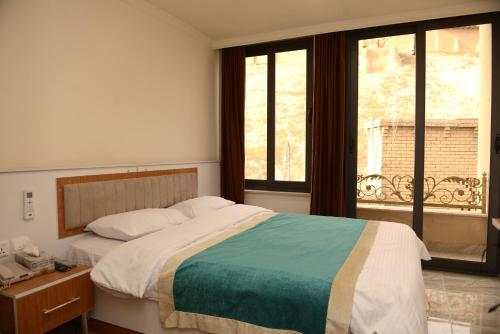 Un dormitorio con una cama grande y una ventana en Syros Hotel Erbil City Center en Erbil