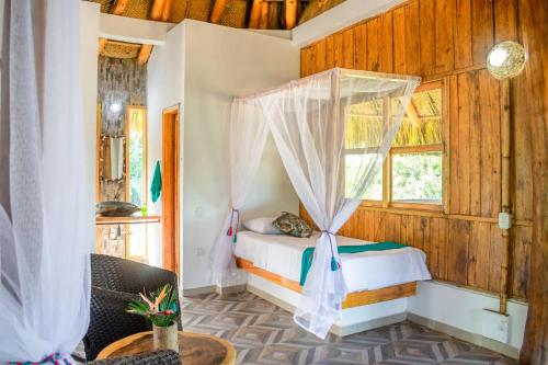 a bedroom with a bed and a window at UUTTAAKA Eco-Hotel in Palomino