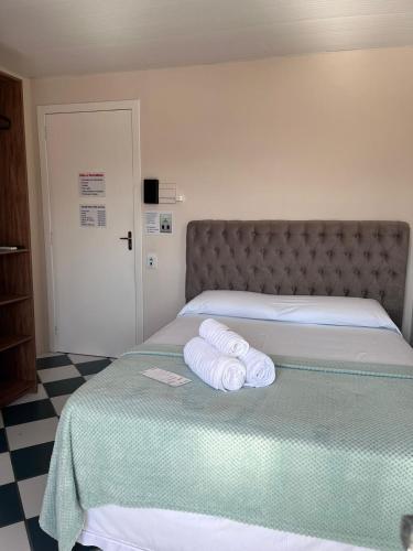 a bedroom with a bed with two towels on it at Morada da Marta in Guarda do Embaú