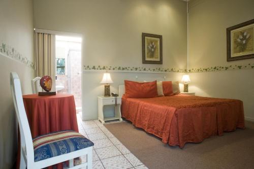 a bedroom with a bed and a table and a chair at Hotel Aranjuez in San José