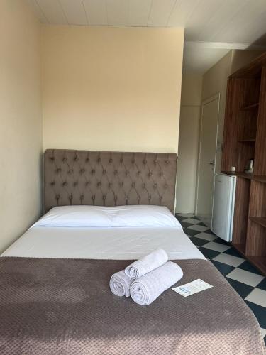 a bedroom with a bed with two towels on it at Morada da Marta in Guarda do Embaú