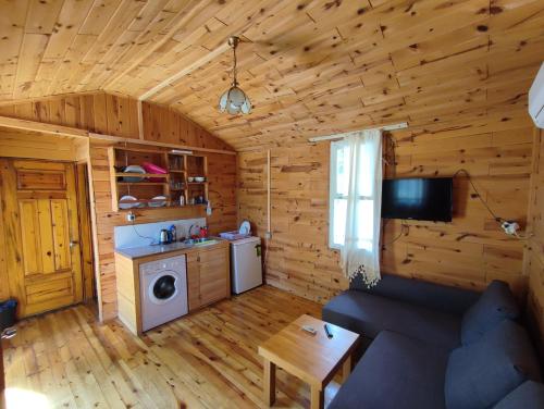 a living room of a log cabin with a washing machine at Lime tree houses in Beldibi