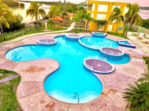 a large pool with blue water in a resort at 2-BR Modern Oceanfront Apt Steps from Playa Sucia in Cabo Rojo