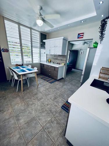 a kitchen with a table and a dining room at 2-BR Modern Oceanfront Apt Steps from Playa Sucia in Cabo Rojo