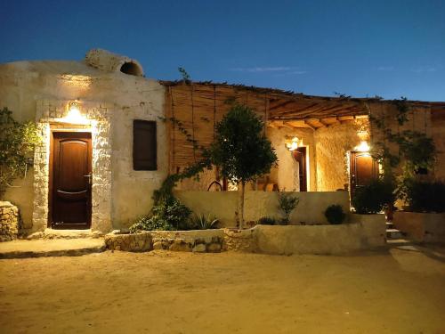 a house with lights on the side of it at Grand Siwa in Siwa