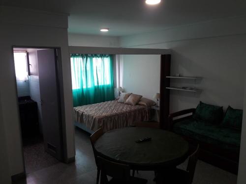 1 dormitorio con 1 cama, 1 mesa y 1 silla en Dpto Olavarria en Mar del Plata