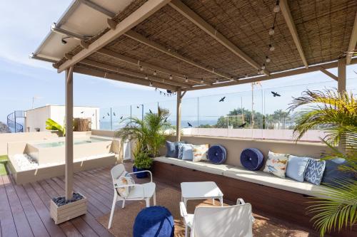a patio with white furniture and a view of the ocean at Garachico Homes - LA CASA DE VICTORIA in Garachico