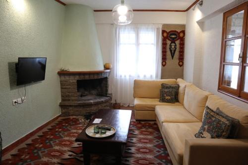 a living room with a couch and a fireplace at Dimos Suite in Arachova