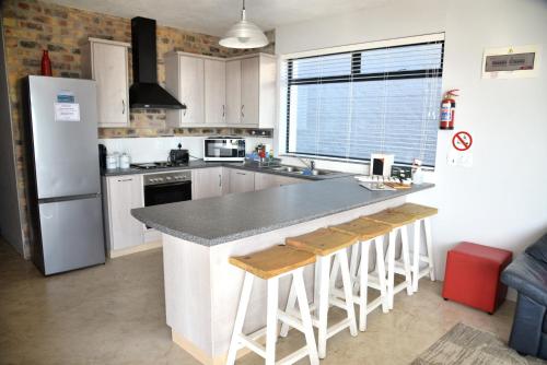 a kitchen with a counter top and a refrigerator at Apt on Beach front, Modern 2BR Solar, 50m to beach in Strandfontein
