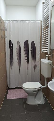baño con cortina de ducha con plumas en Sweet 16 Apartment in the Party District, en Budapest