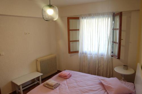 een slaapkamer met een bed en een raam met handdoeken erop bij Dimos Suite in Arachova