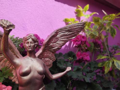 a bronze angel statue sitting in a flower pot at Alo México in Mexico City