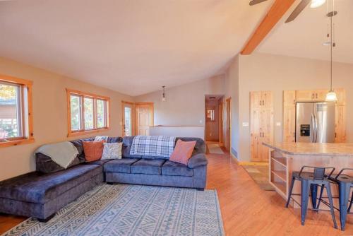 a living room with a blue couch and a kitchen at Fall Getaway Resort-3 KING suites, Dog-Friendly in Seeley