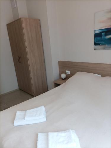 a bedroom with a bed with two towels on it at Червената къща in Perushtitsa