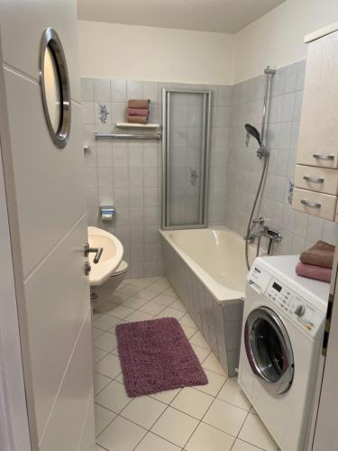 a white bathroom with a washing machine in it at Ferienwohnung „Am Rodenberg“ in Bad Harzburg