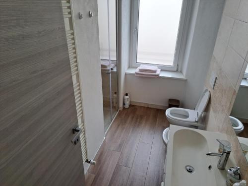 La salle de bains est pourvue de toilettes, d'un lavabo et d'une fenêtre. dans l'établissement VILLA ESTER -Residenze dolomitiche-, à Pieve di Cadore