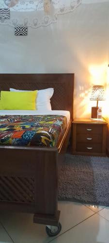 a bedroom with a bed and a lamp on a night stand at Aivilo Home in Kampala