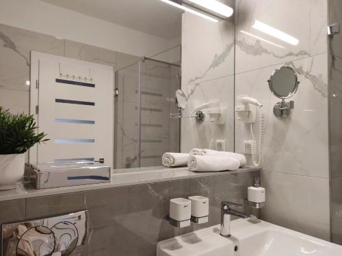 a bathroom with a sink and a mirror at Spa Residence Carbona Mona Lila Apartman in Hévíz