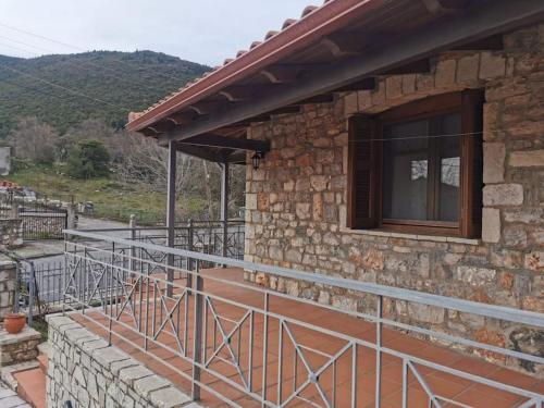 a stone house with a balcony and a window at Ξενώνας Άνθεμις in Levidi