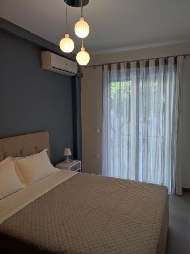 a bedroom with a large bed and a window at Comfy Apartment in Nafplio