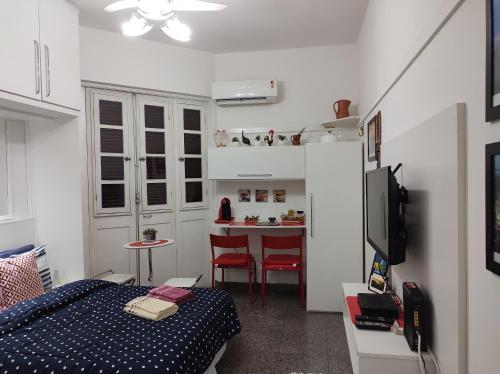 a small bedroom with a bed and a kitchen at Charmoso Studio Ipanema in Rio de Janeiro