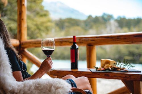 a woman sitting at a table with a glass of wine at Patagonia East River in Llanada Grande