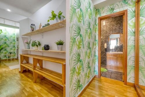 a home office with a desk and a wall with tropical wallpaper at Travel & Live Nature in Porto