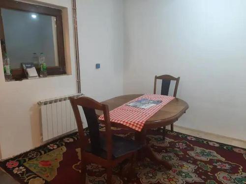 a table and two chairs and a table and a window at Jahorinska planinska kuća in Jahorina