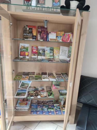 a book shelf filled with lots of books at maison au bord du bois toute équipée avec jaccuzzi in Aywaille