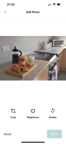 a kitchen counter with a cutting board with croissants on it at Cosy seaside cottage in Criccieth
