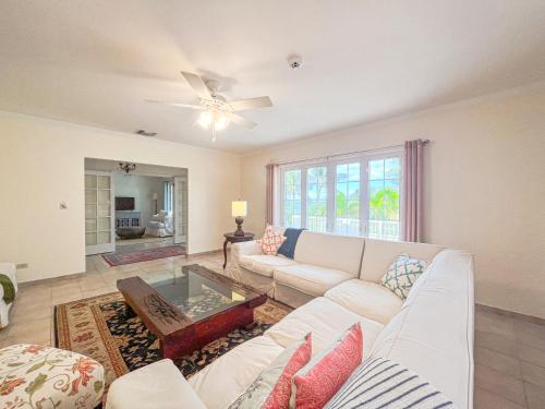 sala de estar con sofá blanco y ventilador de techo en Villa Sea Haven at Orange Hill Beach - Private Pool en Nassau