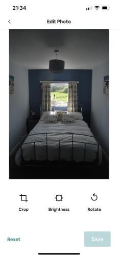 a picture of a bedroom with a bed with a window at Cosy seaside cottage in Criccieth