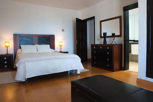 une chambre avec un lit, une commode et un miroir dans l'établissement Casa Hugo, à Tías