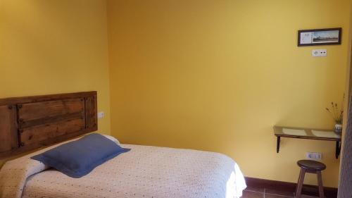 a bedroom with a bed with a blue pillow on it at El Condado Casa Rural in Fuentes de Oñoro