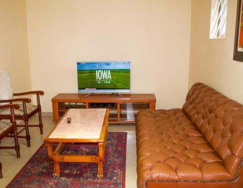 a living room with a couch and a tv at Zenko Suave- 12 Madison West in Johannesburg