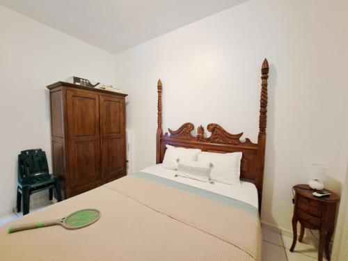 una camera con un grande letto con testiera in legno di Appartement entier à Terre de Haut - Chez Odile a Terre-de-Haut