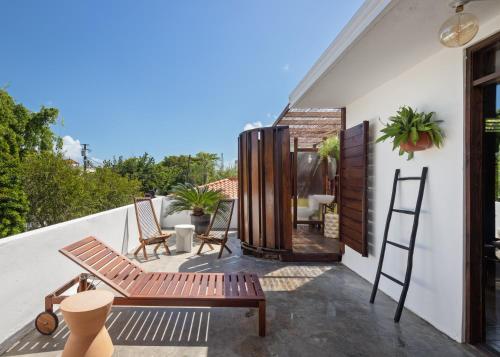 eine Terrasse mit einer Bank und Stühlen auf einem Balkon in der Unterkunft DREAMCATCHER by DW in San Juan