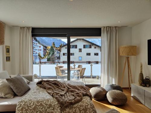 1 dormitorio con cama y ventana grande en Sunnustrahl en Grächen