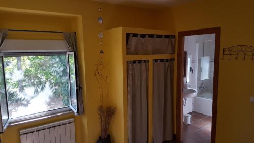 a bathroom with a window and a shower curtain at El Condado Casa Rural in Fuentes de Oñoro