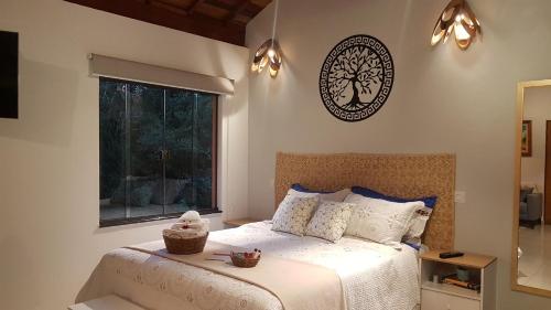 a bedroom with a bed and a clock on the wall at Chalé Canto do Galo 1 in Gonçalves