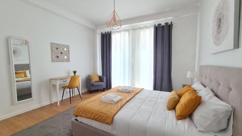 um quarto com uma cama e uma secretária num quarto em Santa Clara Apartments em Ponta Delgada