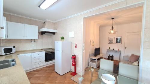 a kitchen with a white refrigerator in a room at Santa Clara Apartments in Ponta Delgada
