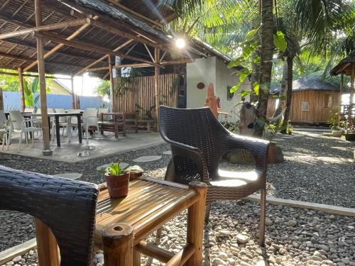 a patio with a wooden table and chairs and a table at La Tortue Diving Resort Dauin in Dauin