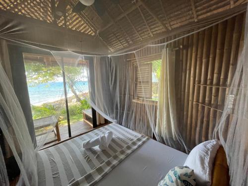 a bedroom with a bed with a view of the ocean at La Tortue Diving Resort Dauin in Dauin