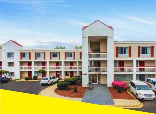 a large apartment building with cars parked in a parking lot at Bposhtels Charlotte in Charlotte